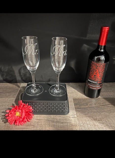 Two champagne flutes on a basket with a wine bottle next to them