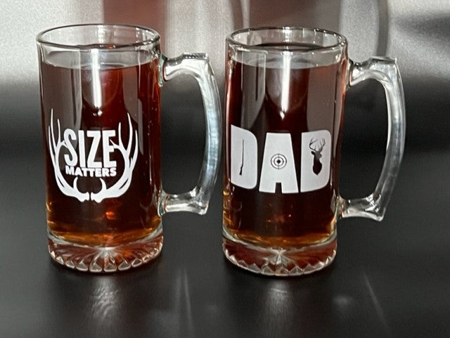 Two beet mugs on a table, filled with beer that say size matter and dad