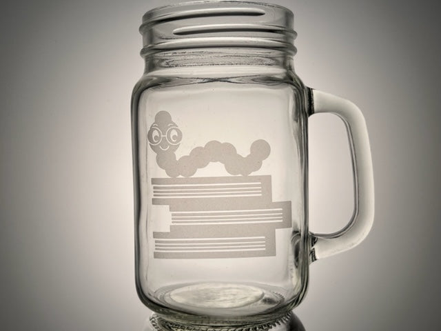 mason jar mug that have three books with a book worm with glasses on top etched on