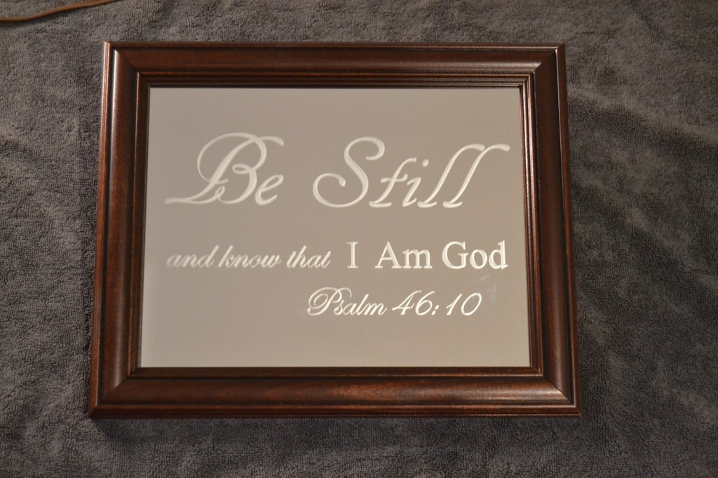 Mirror that says "Be Still and know that I am God Psalm 46:10" with a brown frame