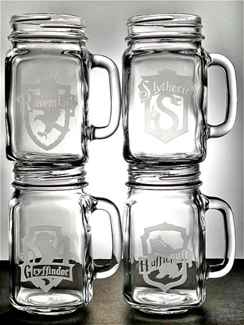 four mason jar mugs that have all have individual Harry Potter houses seals etched on