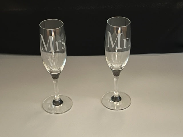 two champagne flutes that have Mrs. and Mr. etched on 